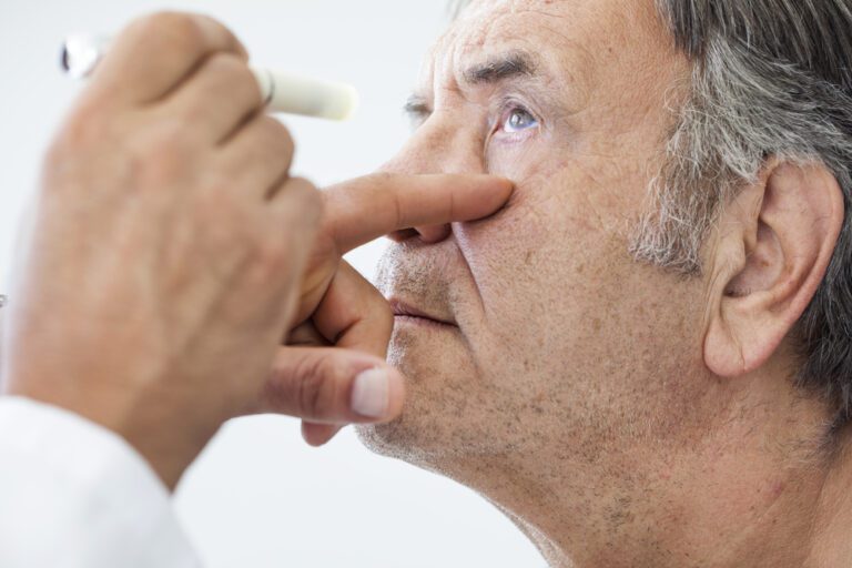 Médico examinando os olhos de seu paciente homem